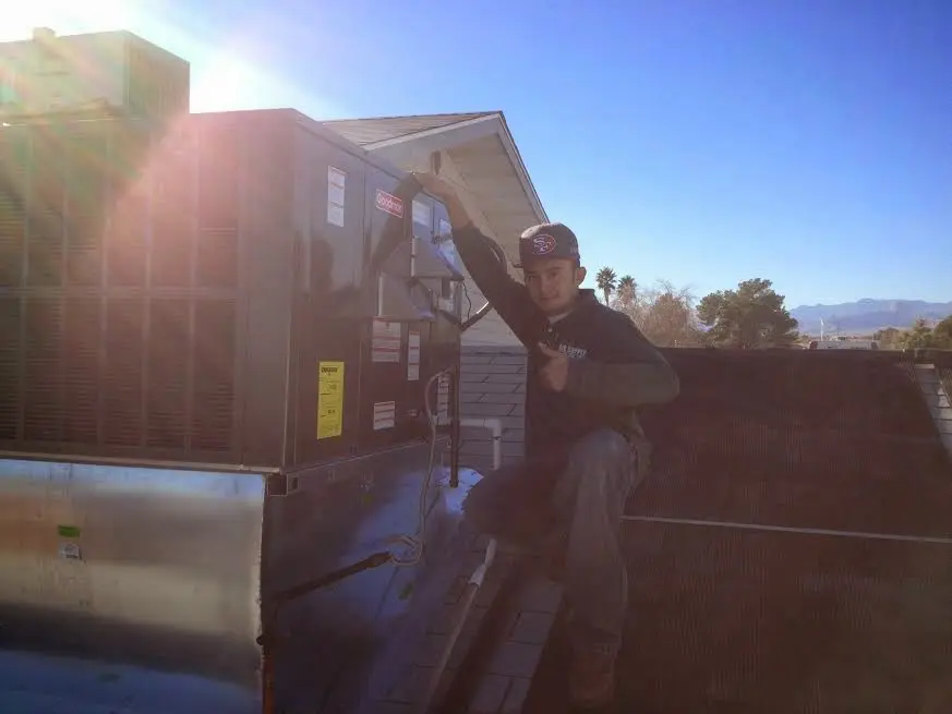 HVAC technician performing Air Duct Cleaning on a rooftop unit in Hinesville